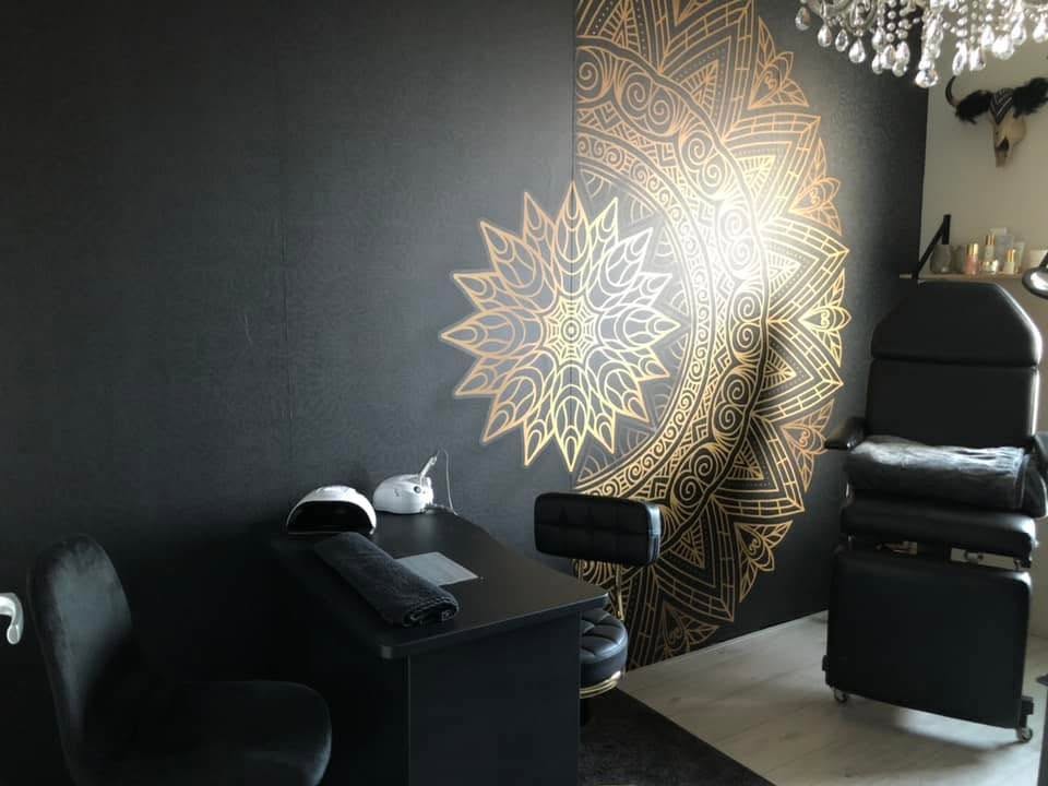 De salon met de nageltafel, de behandelstoel en de gouden mandala