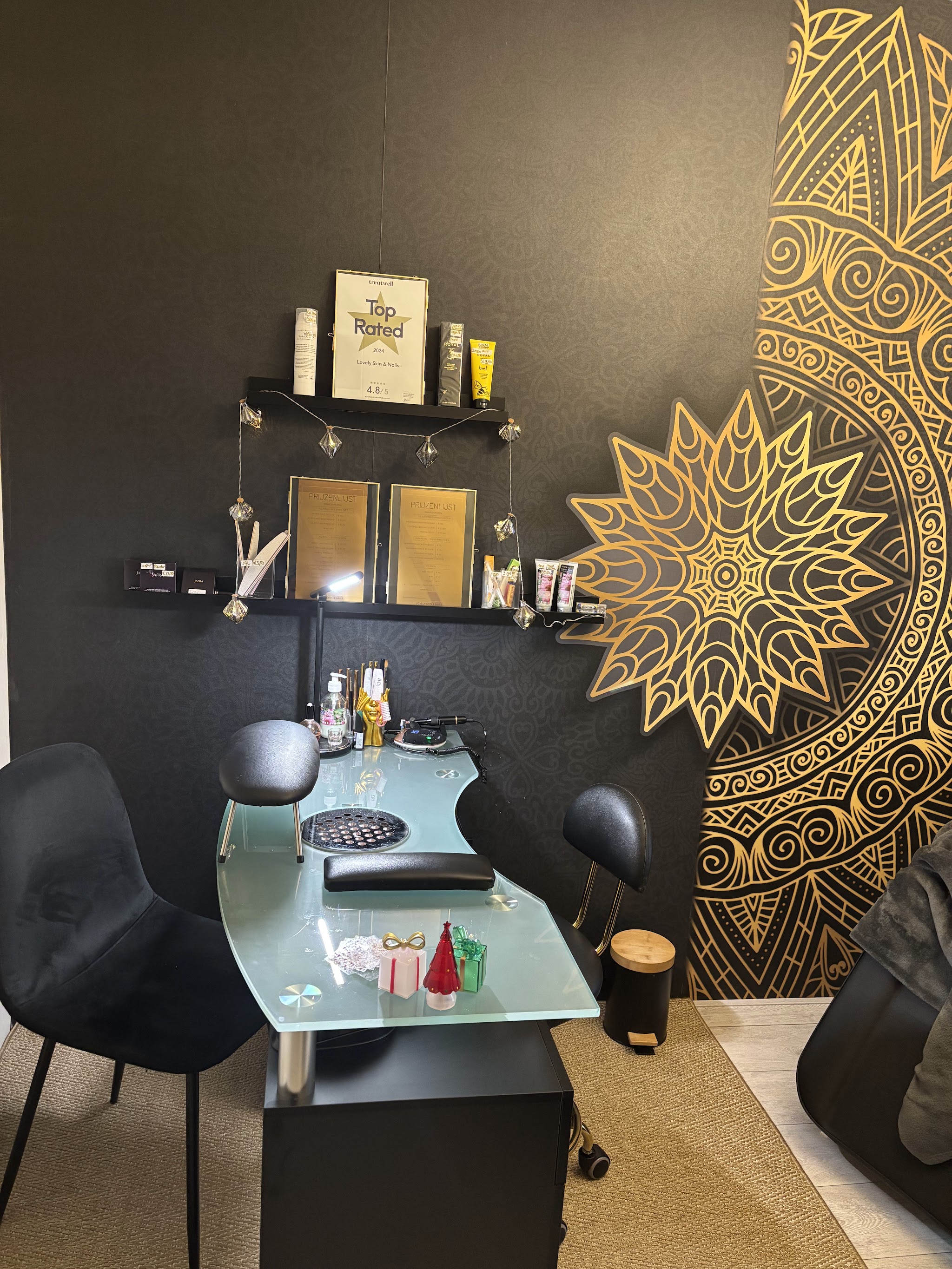 De nagelhoek met de glazen tafel en de gouden mandala op de zwarte wand
